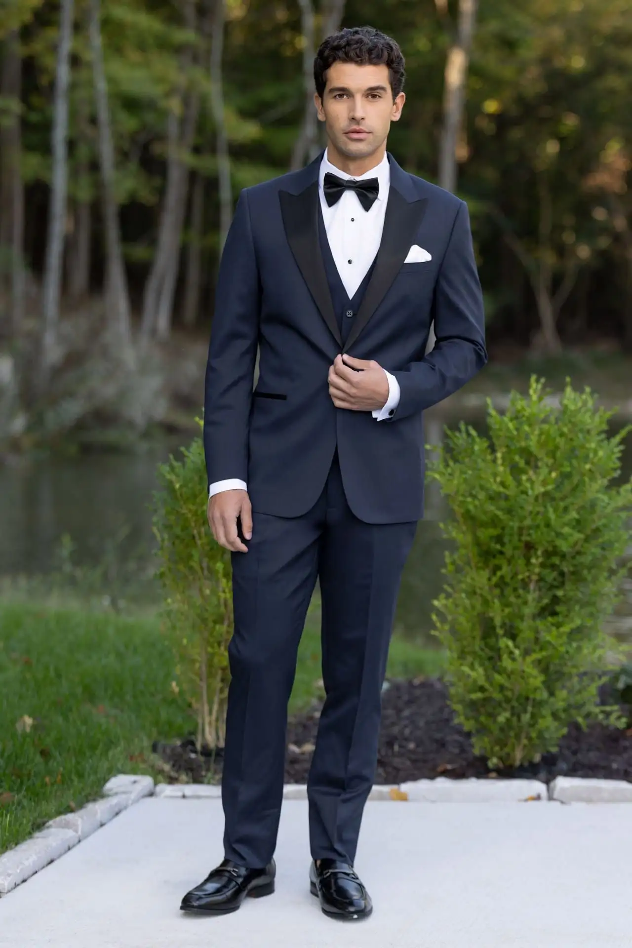 Jim's Formal Wear navy suit with satin peak lapels, matching vest, and a black bow tie