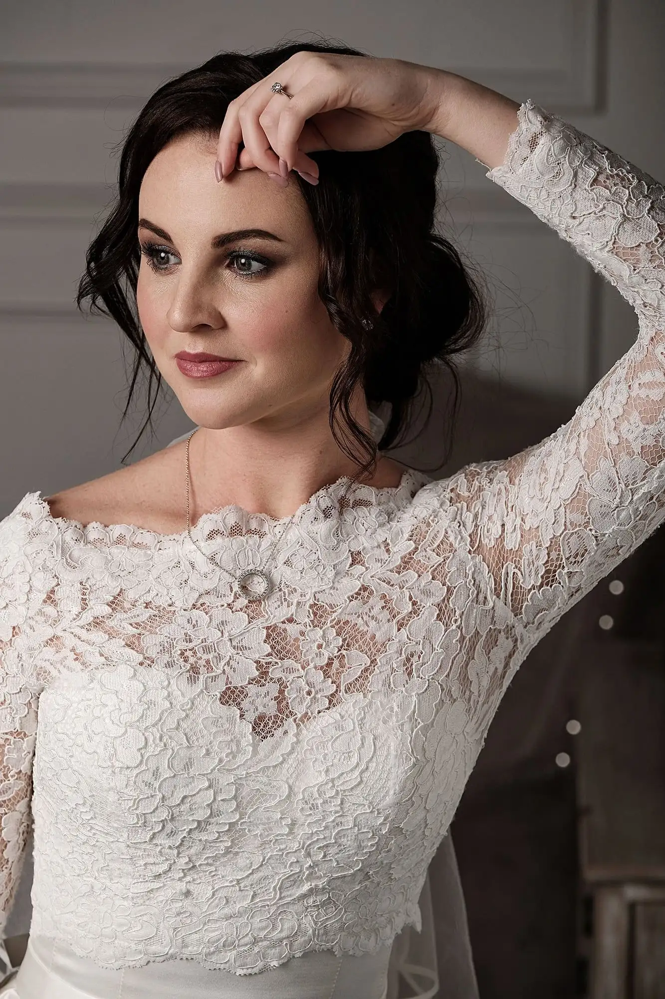 Off-the-shoulder lace wedding gown with long sleeves, shown in close-up