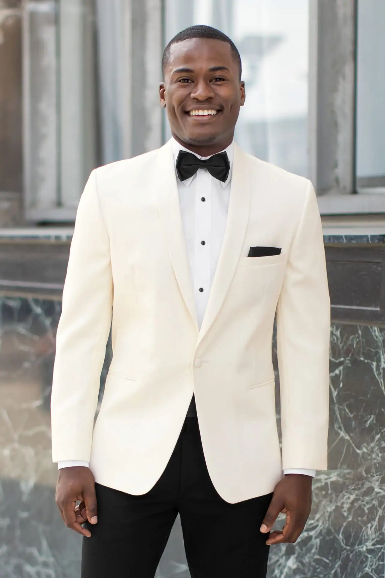 Jim's Formal Wear ivory dinner jacket with a shawl lapel, black trousers, and a black bow tie