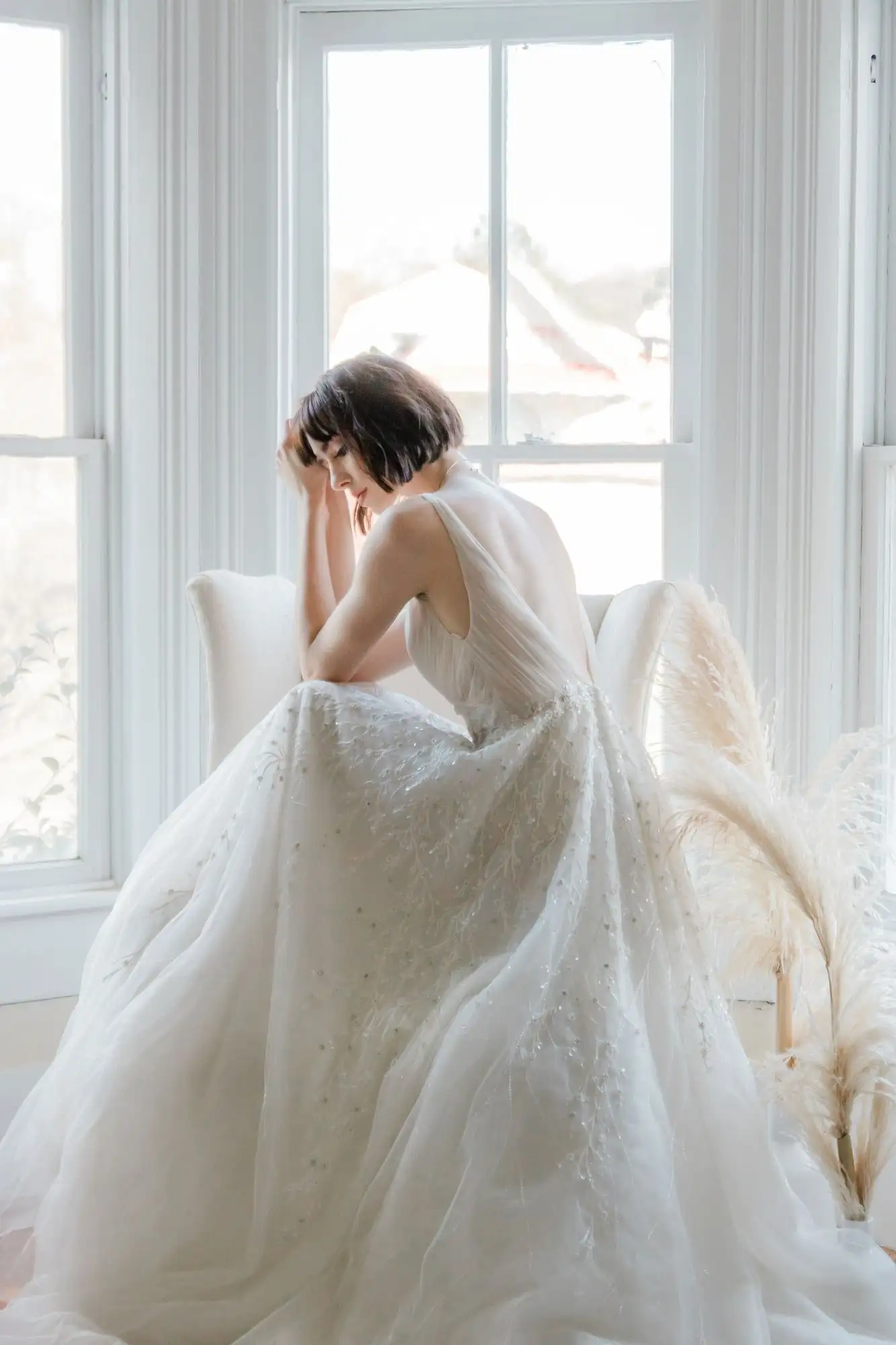 Beaded wedding ball gown with a low back, shown from behind in soft window light
